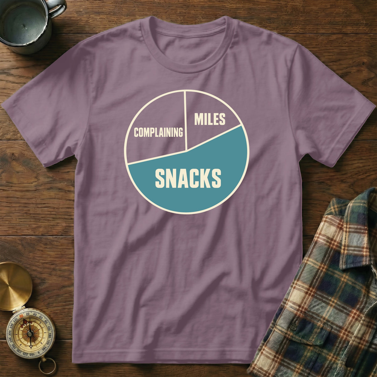 Purple t-shirt with a pie chart graphic reading "Complaining," "Miles," and "Snacks."