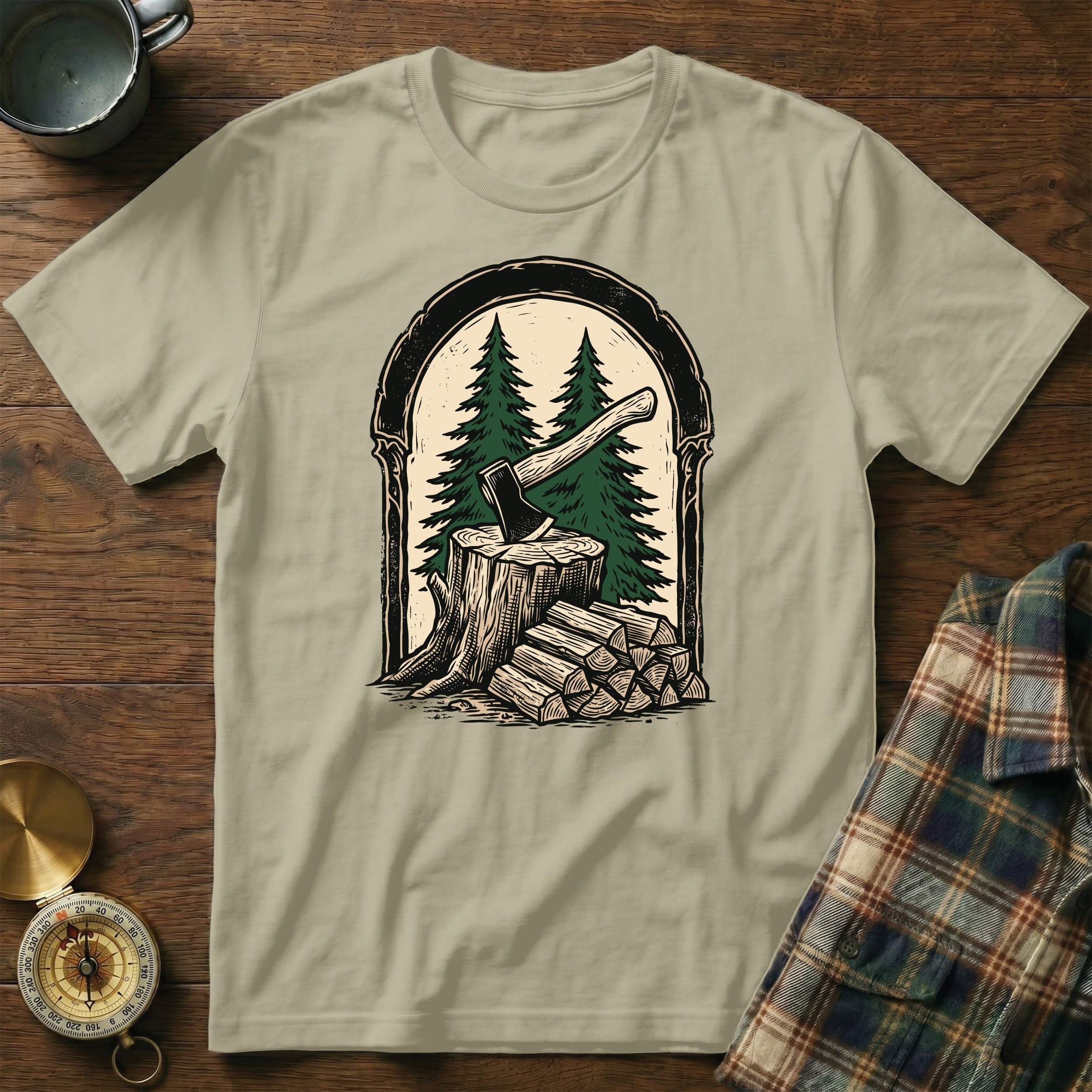 T-shirt with ax and firewood graphic framed by trees and an arch.