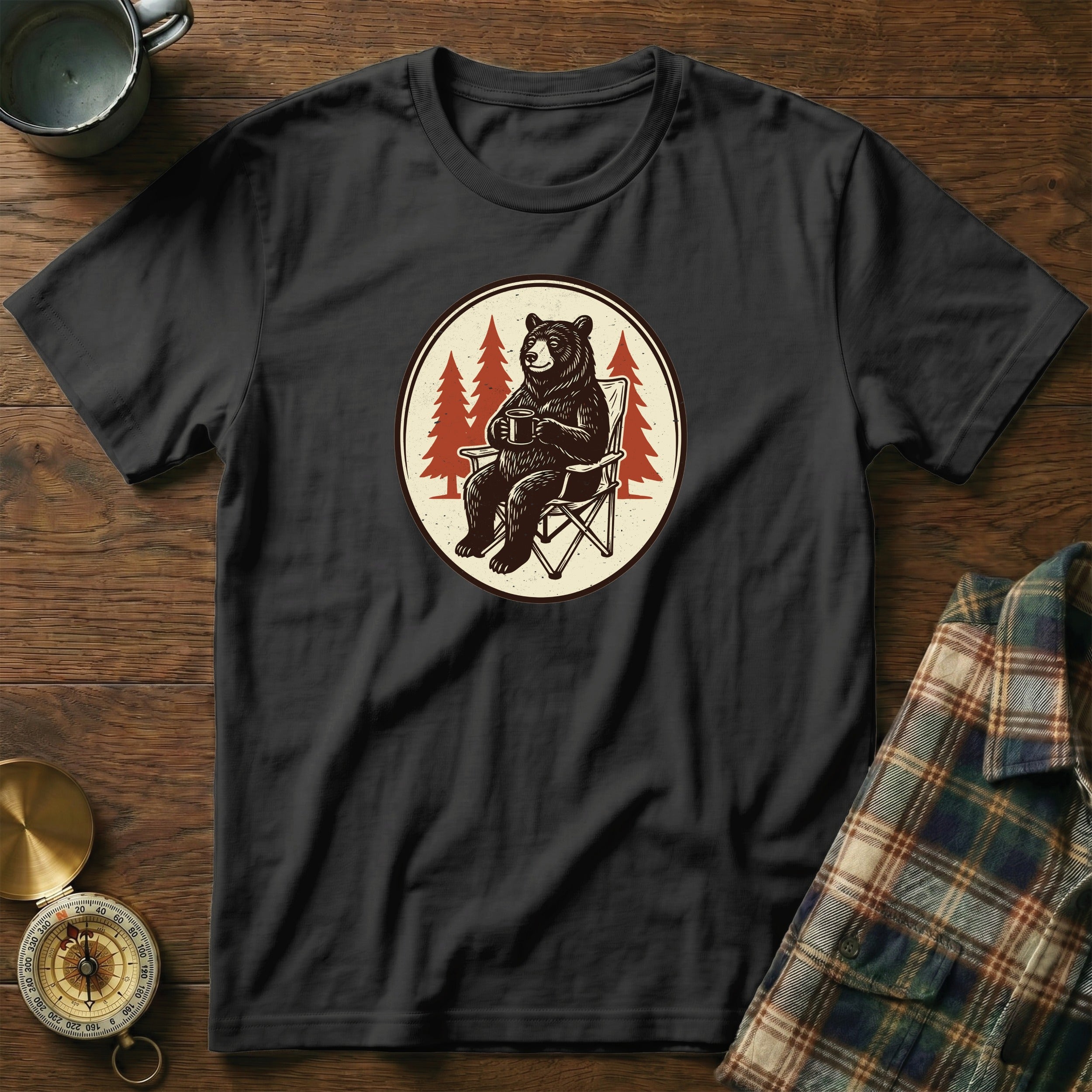 Black t-shirt with a circular graphic of a bear sitting in a camping chair with a mug.