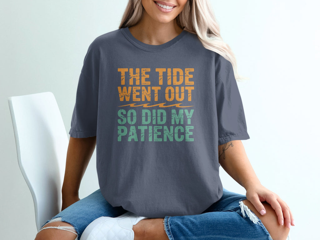 Dark gray t-shirt with orange and green text reading "THE TIDE WENT OUT SO DID MY PATIENCE".
