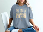 Gray t-shirt with "The ocean doesn't care either" text and a wave graphic.