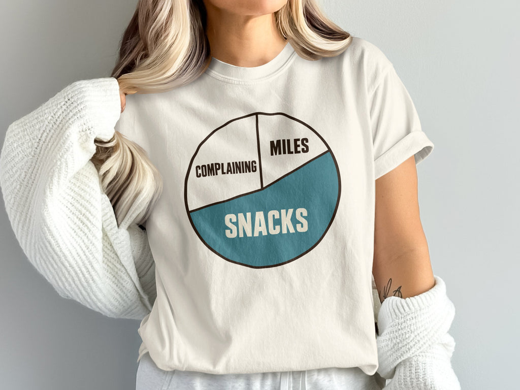 Cream t-shirt with pie chart graphic reading "Complaining," "Miles," and "Snacks."