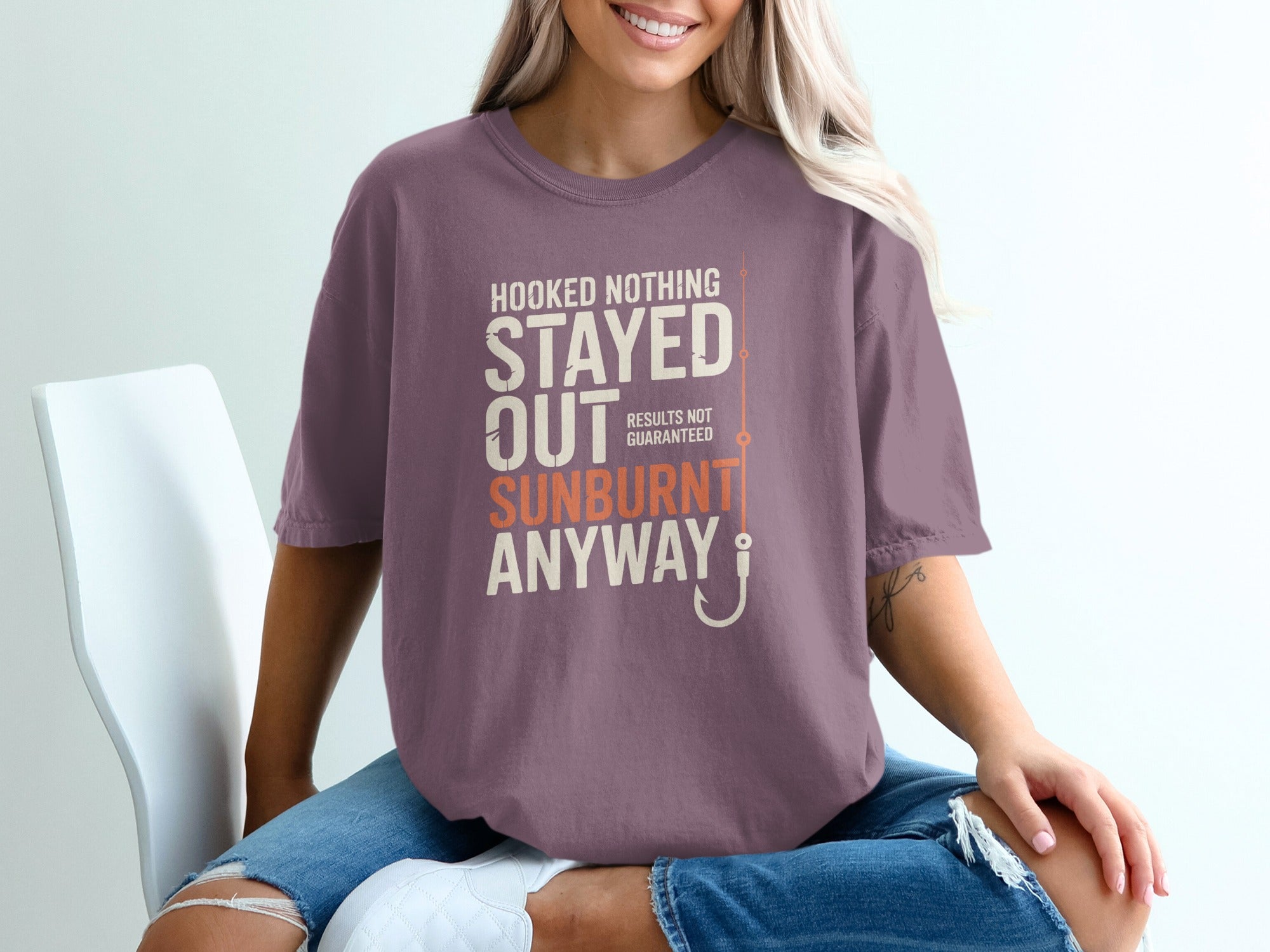 Mauve t-shirt with "Hooked Nothing Stayed Out Sunburnt Anyway" and a fishing hook.