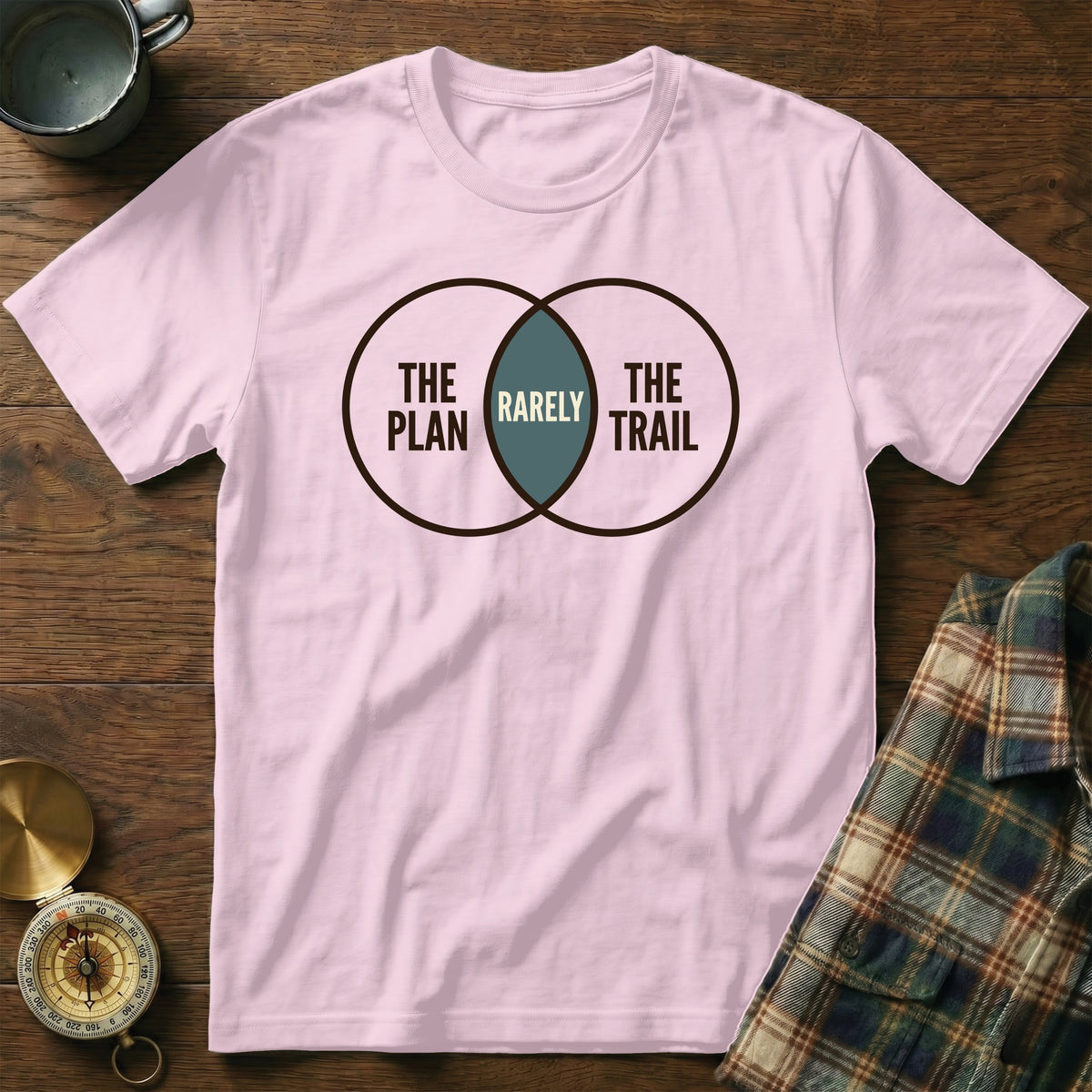 Pink t-shirt with Venn diagram graphic: "THE PLAN", "RARELY", "THE TRAIL".