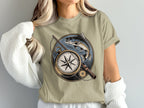 T-shirt with circular design of compass, fishing rod, and leaping fish.
