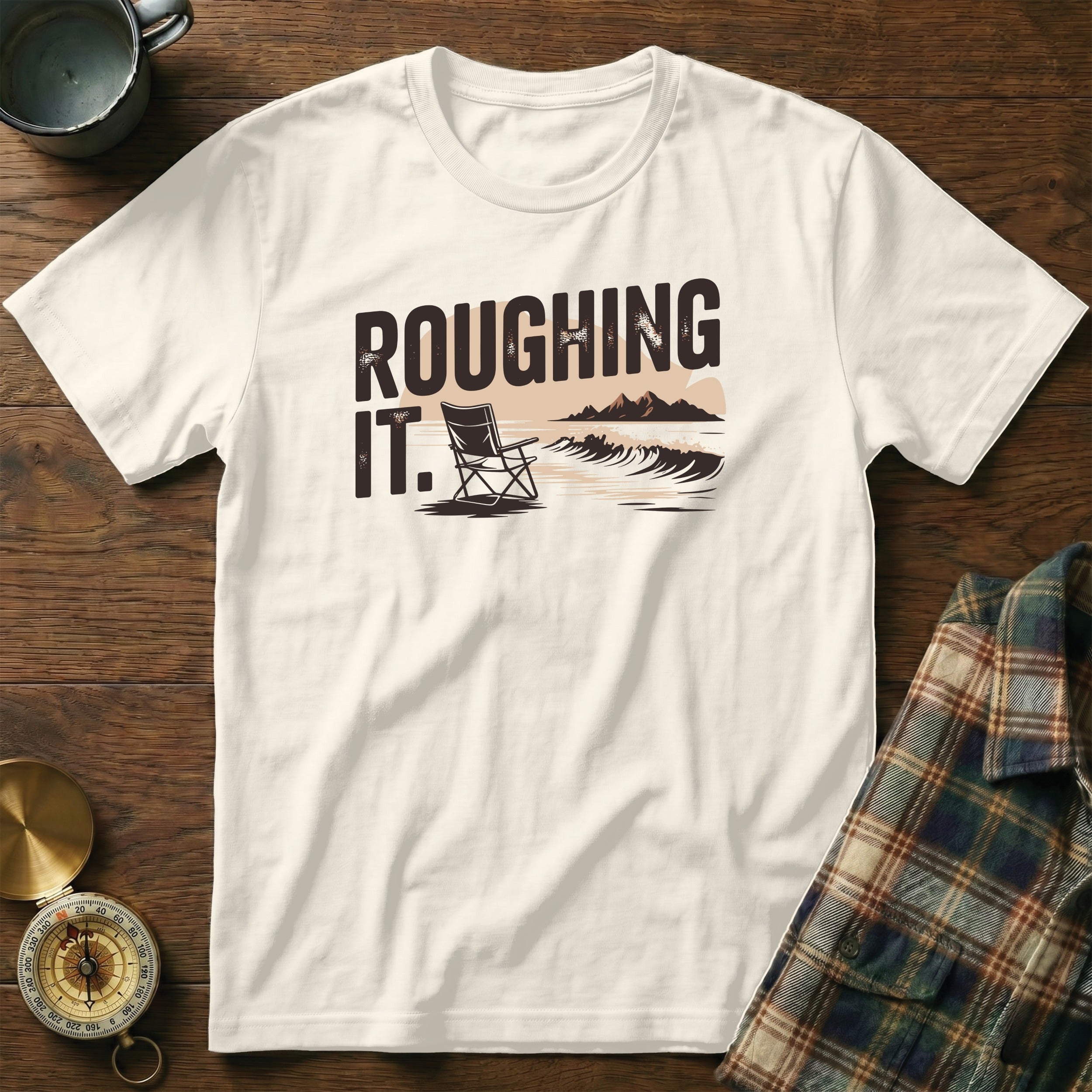 White t-shirt with "ROUGHING IT." text and a beach scene graphic.
