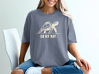 Graphic t-shirt with a beige sea turtle carrying a backpack and the text "ON MY WAY."