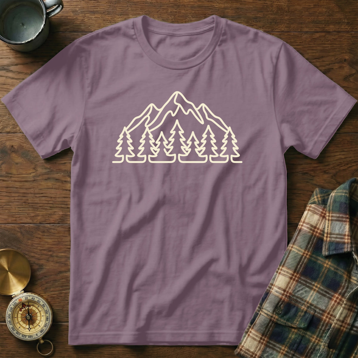 Purple t-shirt with outline graphic of mountains and pine trees.