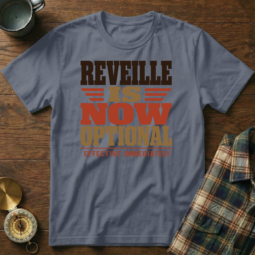 A slate gray t-shirt with brown, orange, and tan lettering that reads "REVEILLE IS NOW OPTIONAL EFFECTIVE IMMEDIATELY".