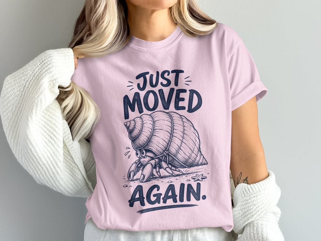 Hermit crab on pink t-shirt with text "JUST MOVED AGAIN."