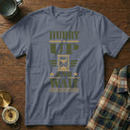 A slate grey t-shirt featuring military-style text that reads HURRY UP AND WAIT with an hourglass graphic.