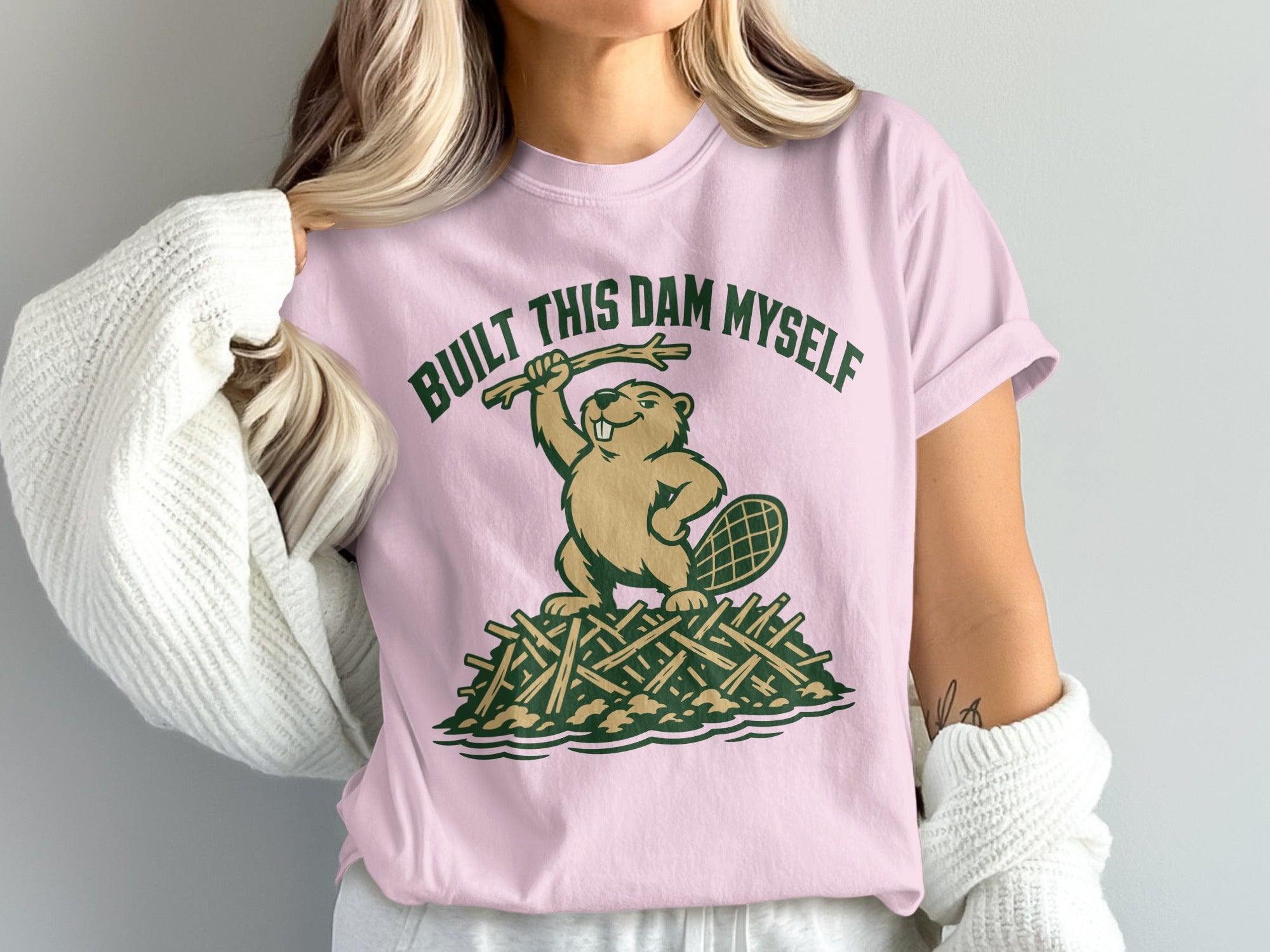 Pink t-shirt with a beaver standing on a dam, holding a stick, text reads "BUILT THIS DAM MYSELF".