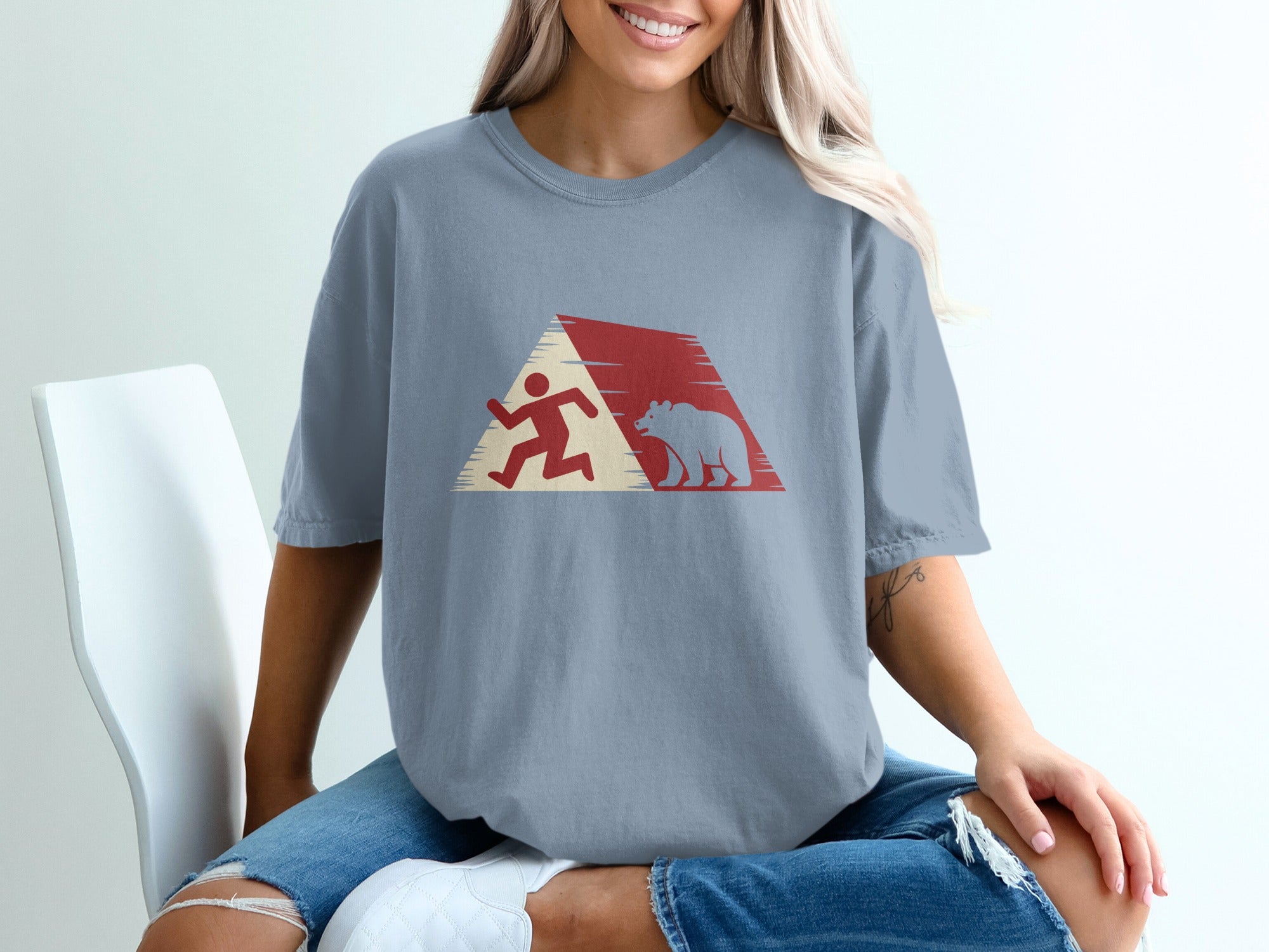 Runner and bear silhouette within a red and white abstract mountain design on a grey t-shirt.