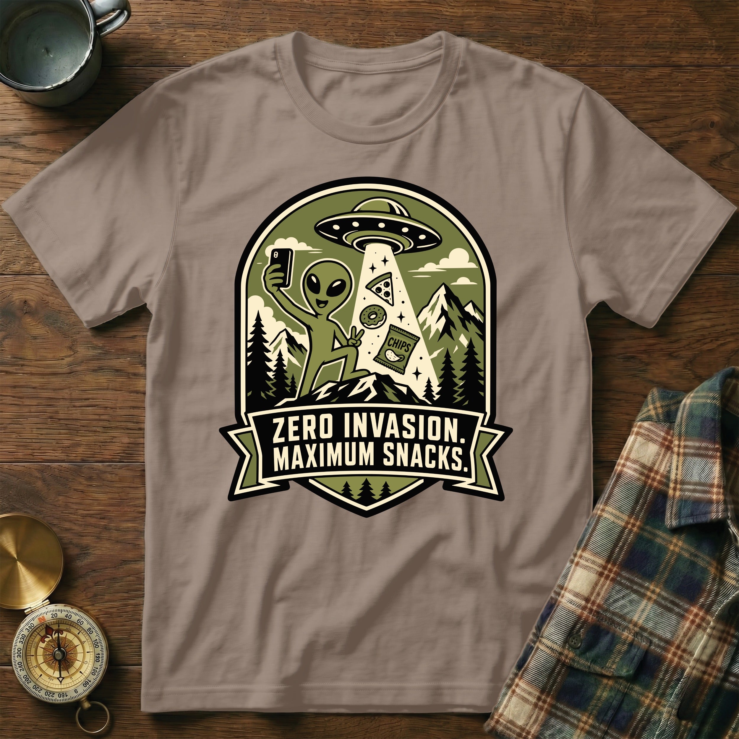 T-shirt with graphic of an alien taking a selfie with pizza, donut, and chips from a UFO.