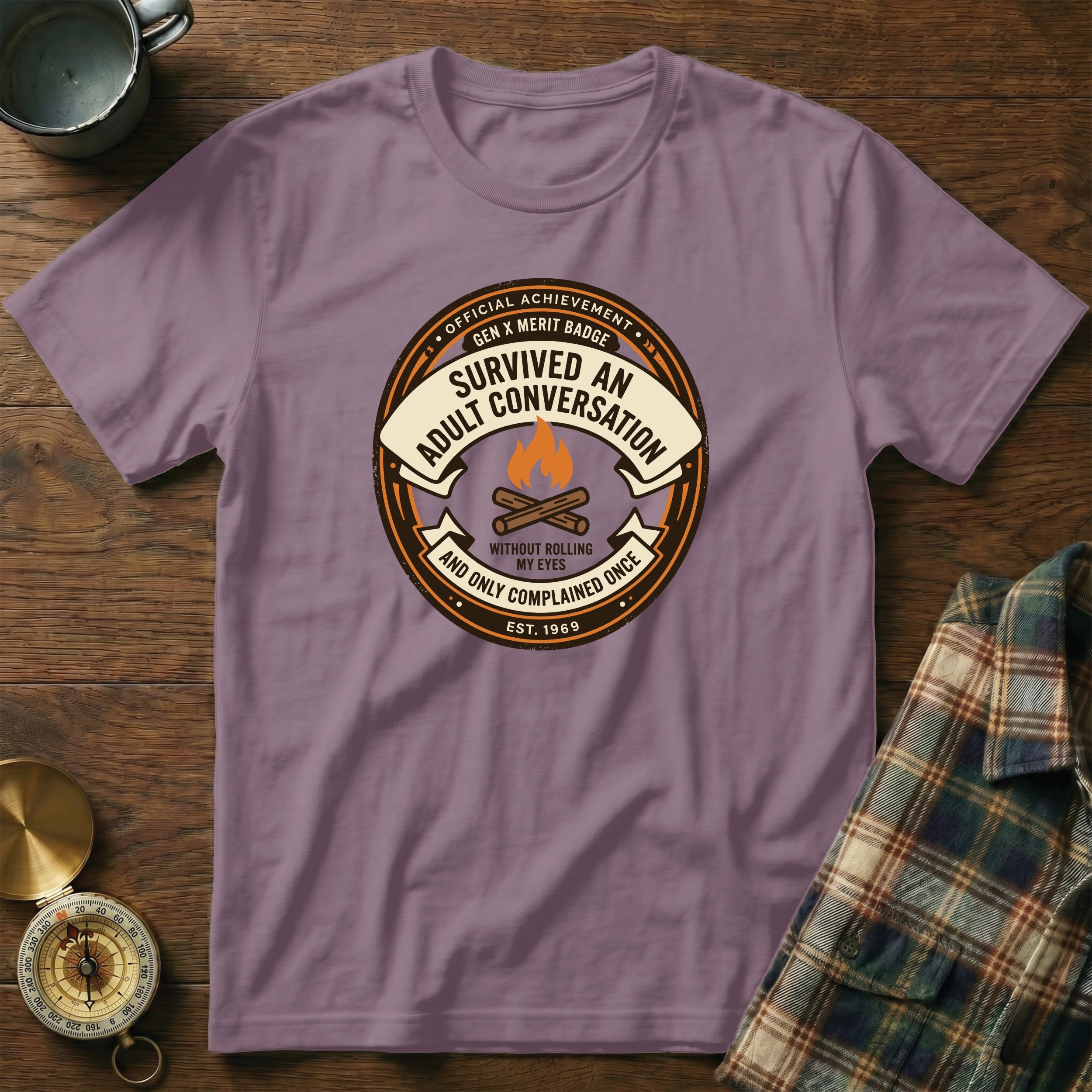Purple t-shirt with "Gen X Merit Badge: Survived an Adult Conversation" text and badge design.