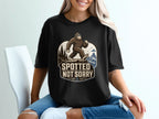 Bigfoot wearing sunglasses walking on a cliff with the text "Spotted Not Sorry".