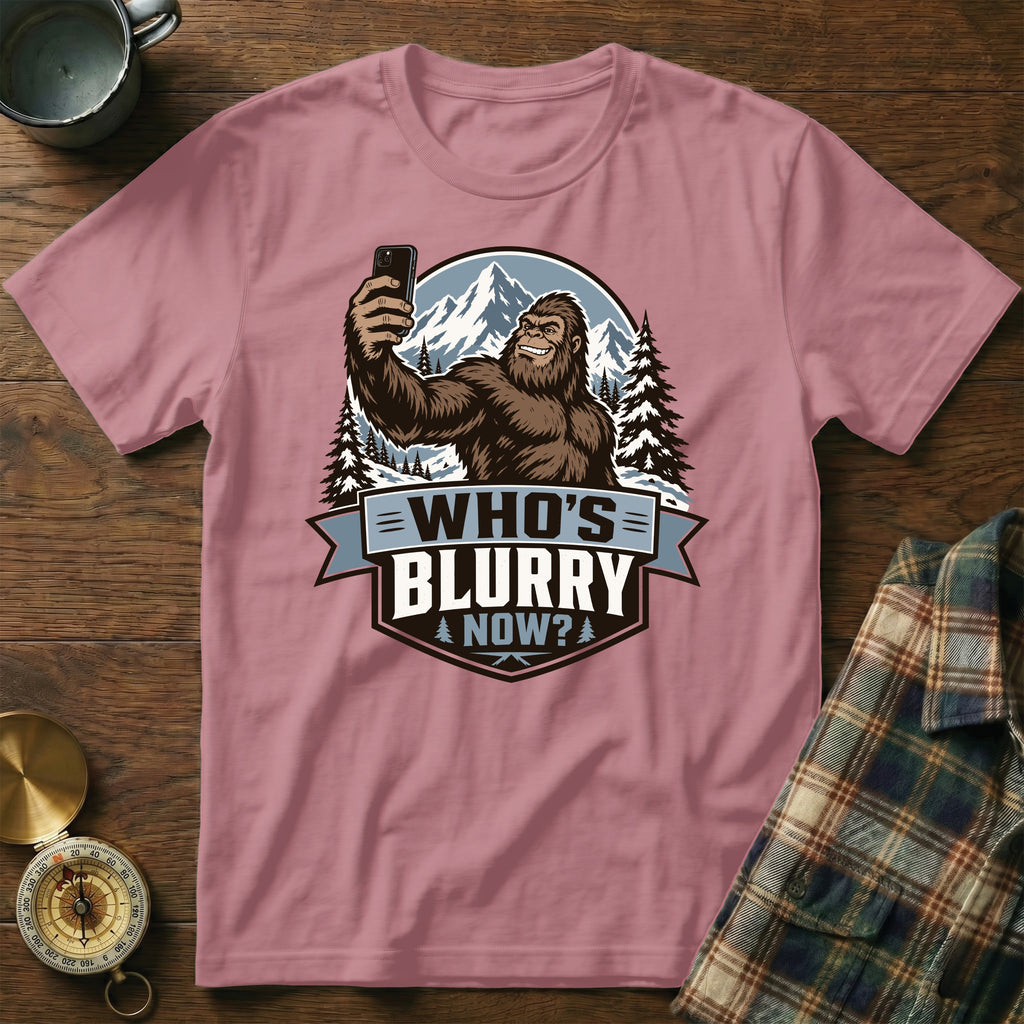 Bigfoot taking a selfie with mountains behind, text "Who's Blurry Now?".