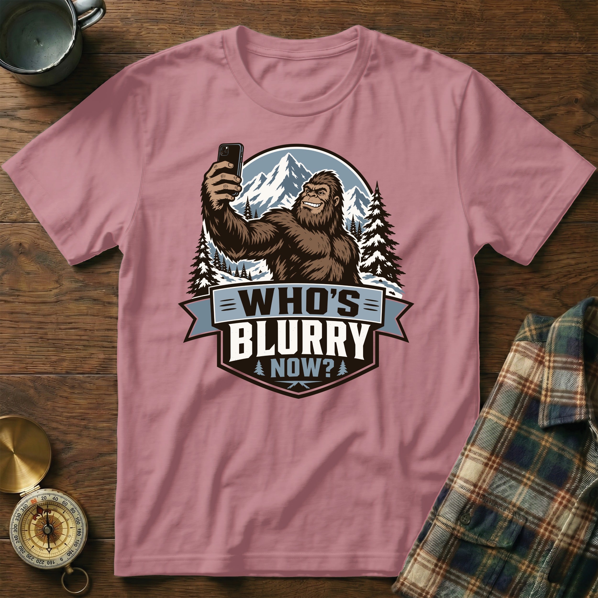 Bigfoot taking a selfie with mountains behind, text "Who's Blurry Now?".