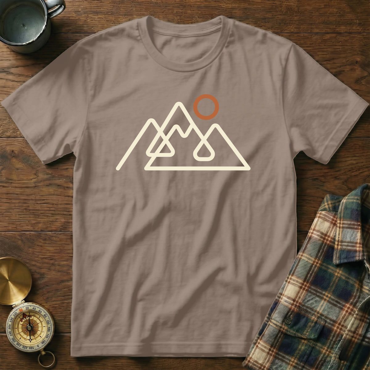 Brown t-shirt with a cream outline graphic of mountains and a sun.