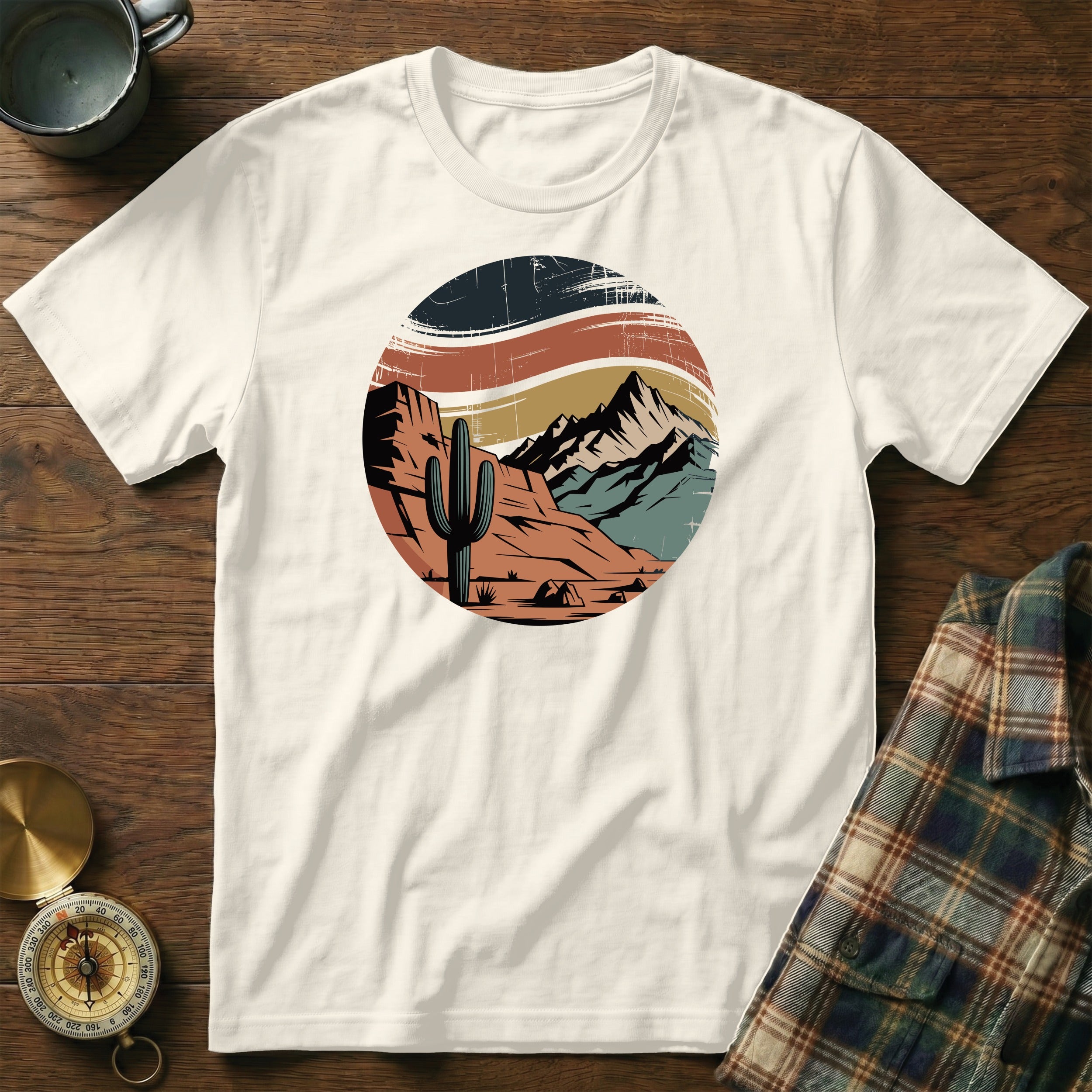 Cream t-shirt with circular desert landscape graphic featuring cactus and mountains.