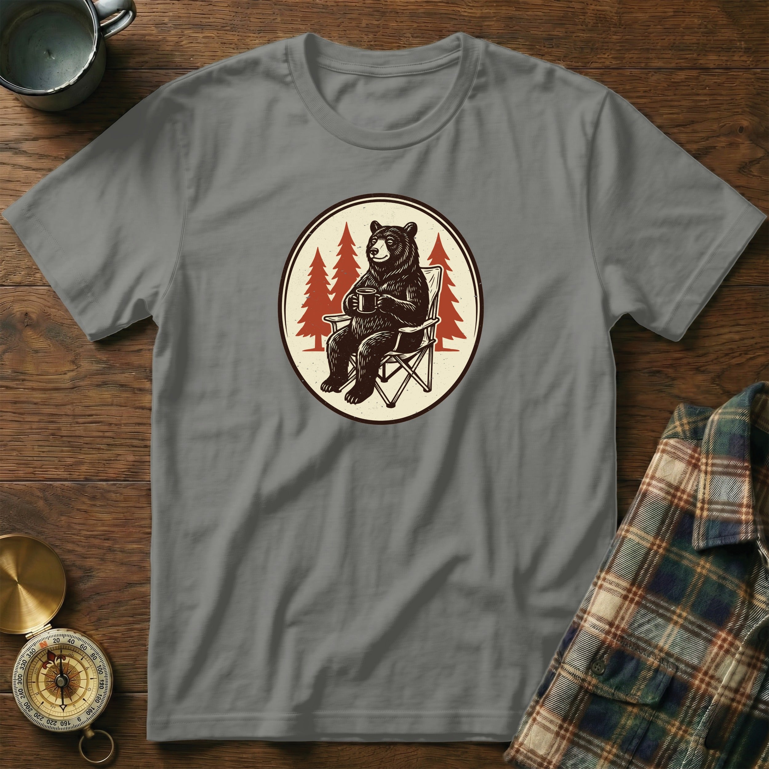 Grey t-shirt with a graphic of a bear in a camping chair holding a mug.