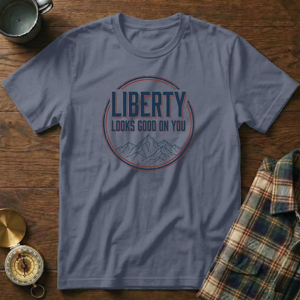Blue t-shirt with "LIBERTY LOOKS GOOD ON YOU" text and mountain graphic.