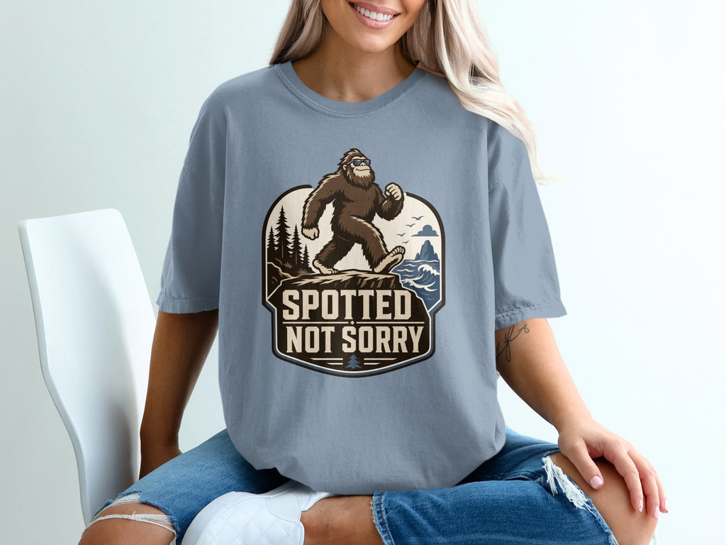 Bigfoot graphic t-shirt with text "SPOTTED NOT SORRY" and nature scene.