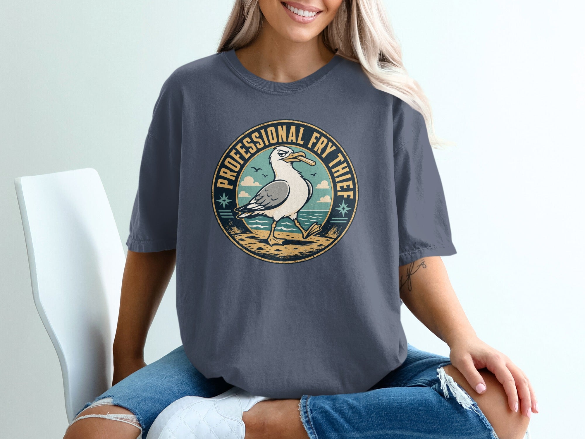 Graphic t-shirt with distressed detailing and a circular seagull design reading "Professional Fry Thief".