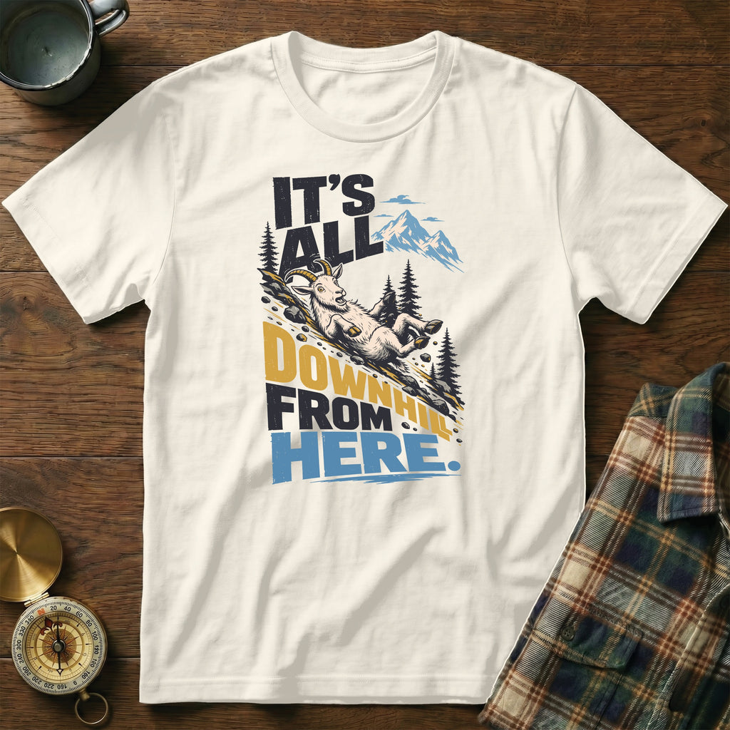 A cream crewneck t-shirt featuring a graphic of a goat sliding down a mountain with the text It's All Downhill From Here.