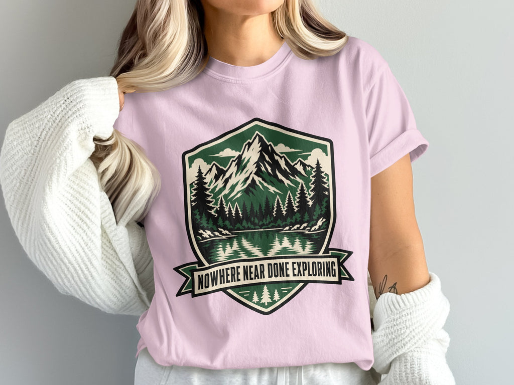 Pink t-shirt with a nature graphic and the text "Nowhere Near Done Exploring."