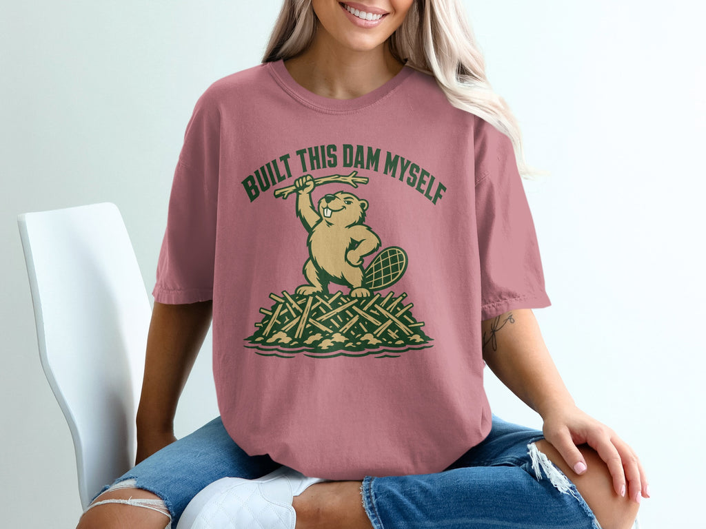 T-shirt graphic of beaver holding stick, text "BUILT THIS DAM MYSELF".