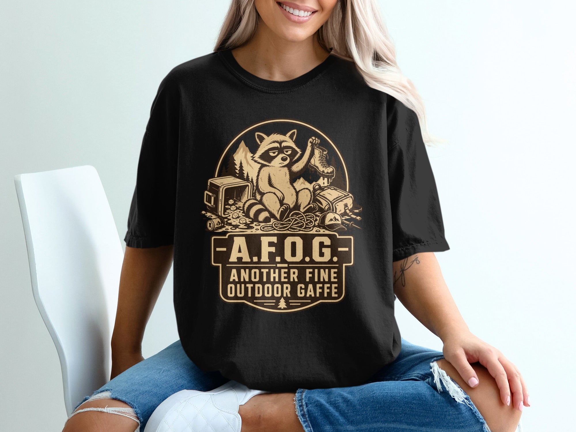 Black t-shirt with raccoon graphic and "A.F.O.G. Another Fine Outdoor Gaffe" text.