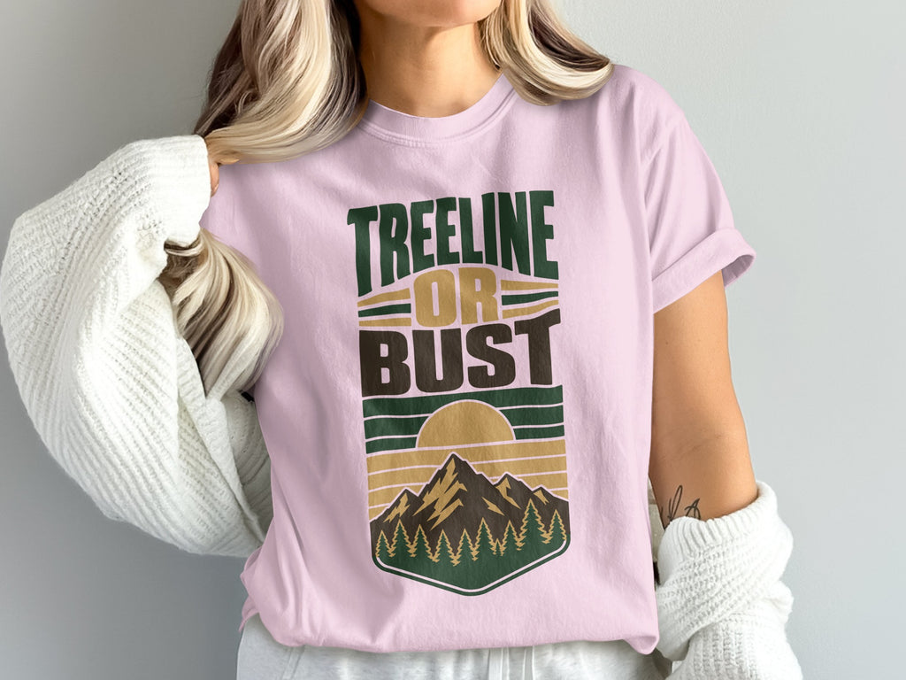 Pink t-shirt with "TREELINE OR BUST" text and a mountain sunset graphic.