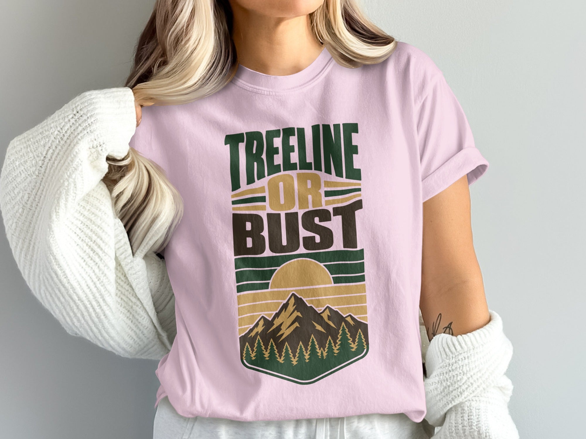 Pink t-shirt with "TREELINE OR BUST" text and a mountain sunset graphic.