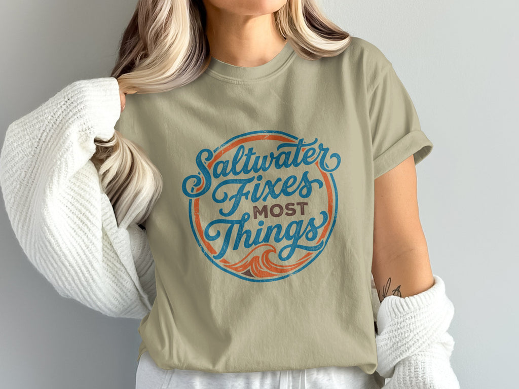 Tan t-shirt with circular "Saltwater Fixes Most Things" text design.