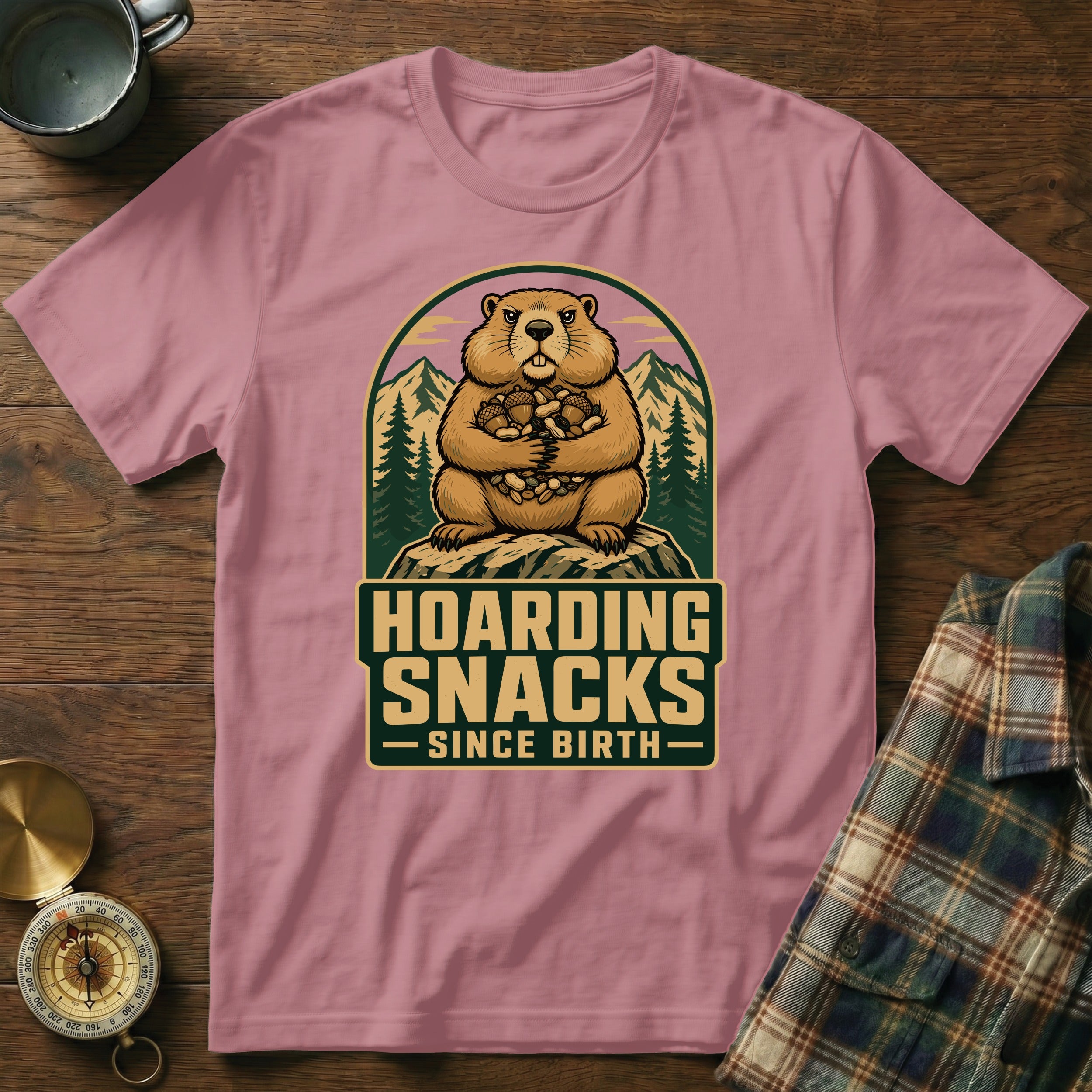 Groundhog hoarding snacks design on a pink t-shirt with text "HOARDING SNACKS SINCE BIRTH".