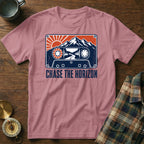 Pink t-shirt with a cassette tape design featuring mountains, sun, and the text "CHASE THE HORIZON".
