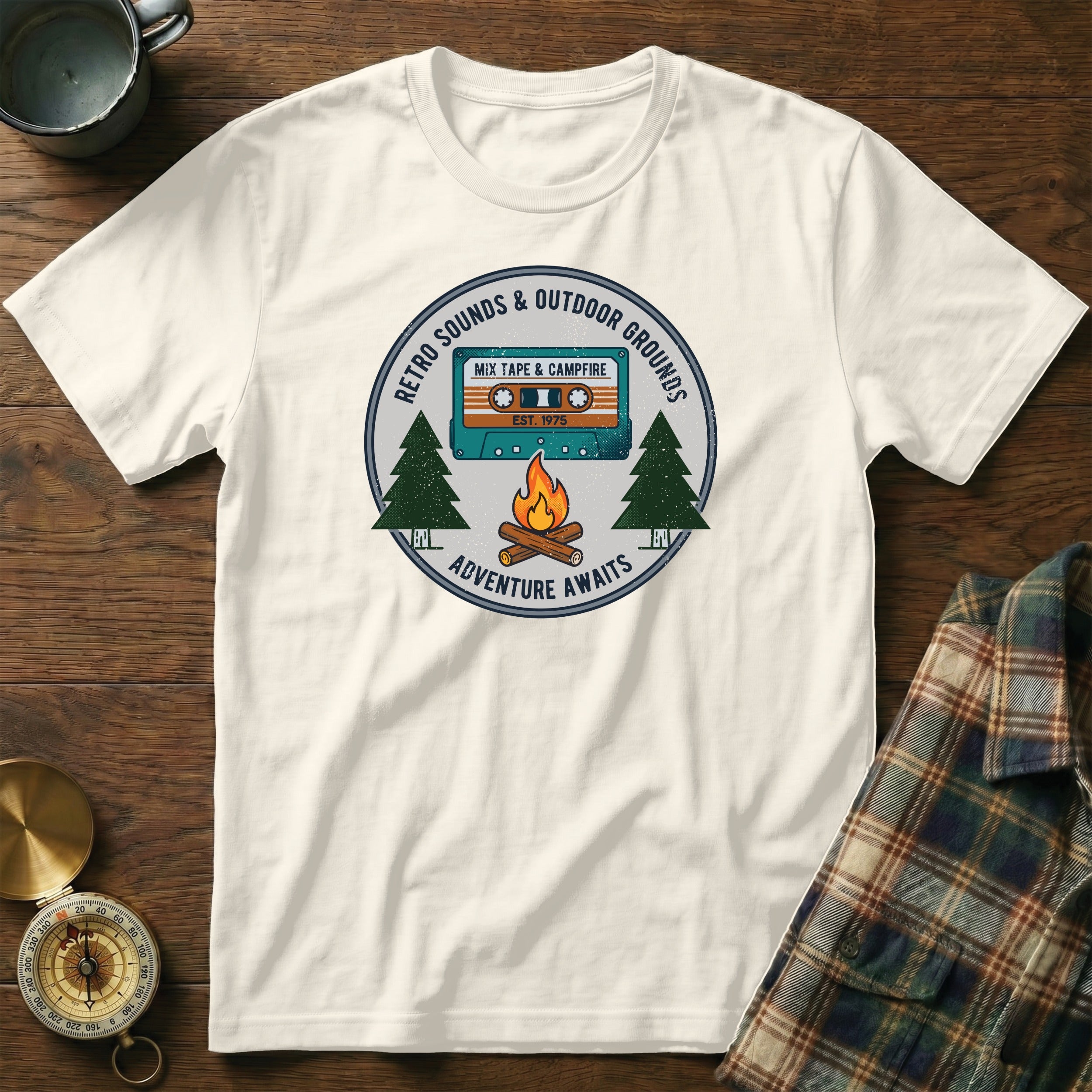 T-shirt graphic with retro cassette, campfire, trees, and text.
