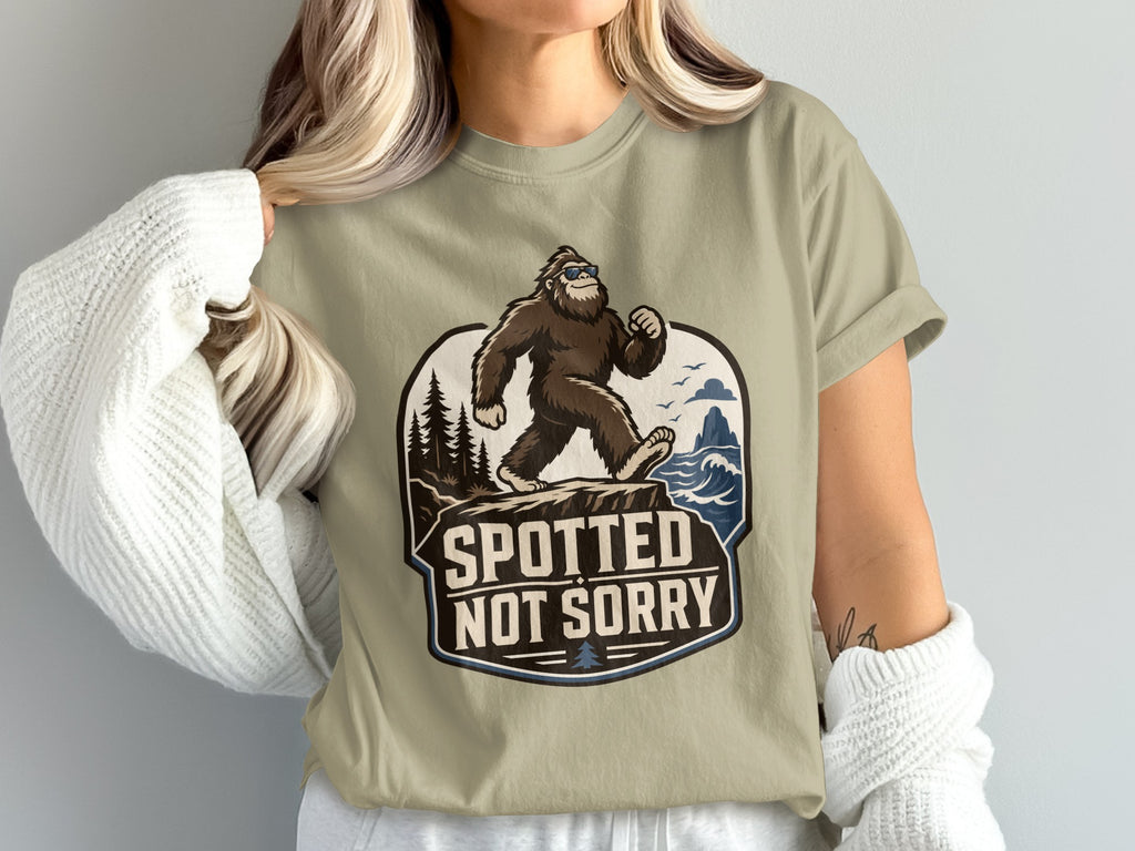 Bigfoot wearing sunglasses walking on a cliff, with text "Spotted Not Sorry".
