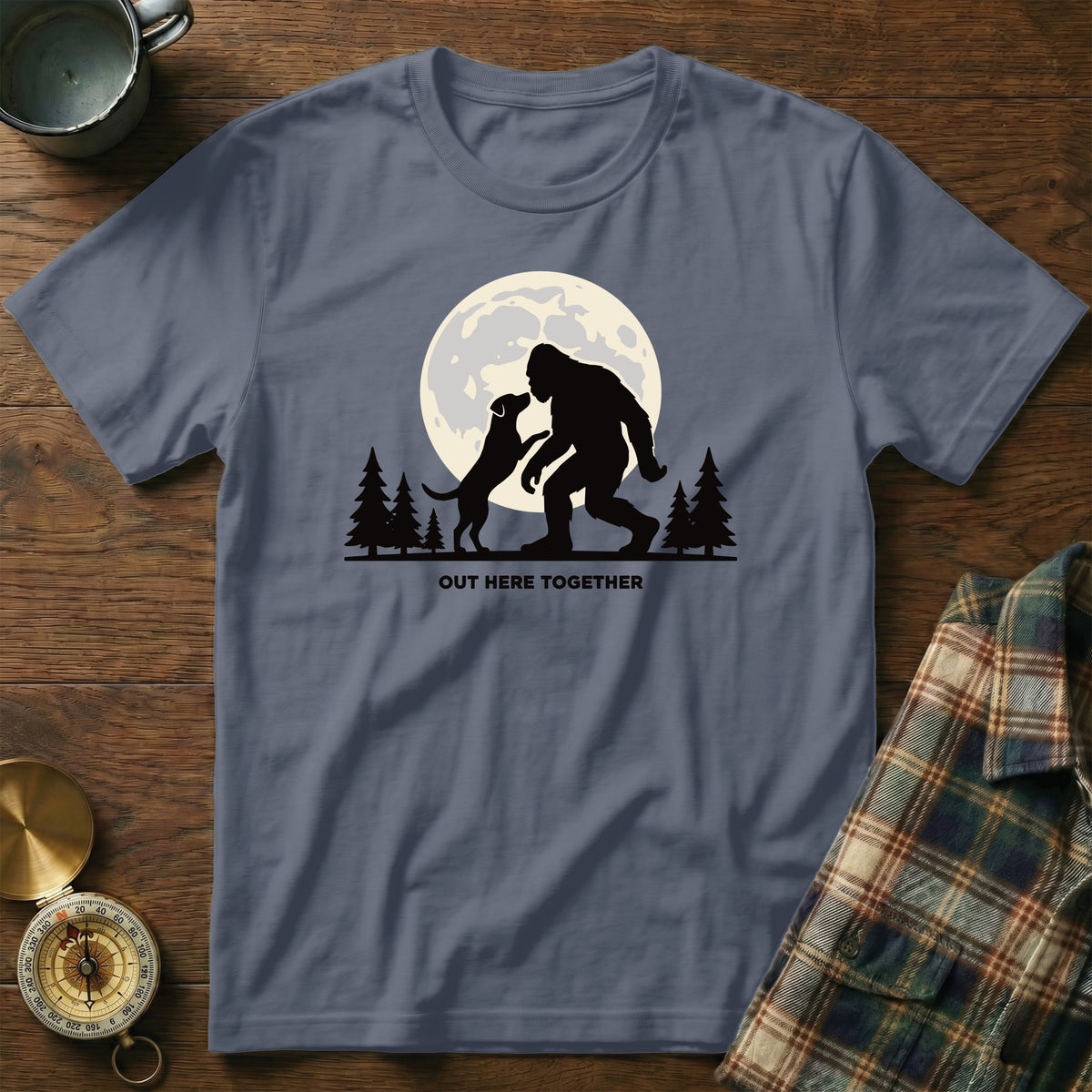 Bigfoot and dog silhouette in front of a moon with text "OUT HERE TOGETHER".