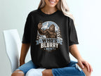 Bigfoot taking a selfie in a snowy mountain landscape with text "Who's Blurry Now?"