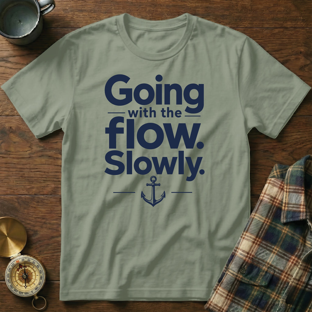 Sage green crewneck t-shirt with navy blue text reading Going with the flow. Slowly. and an anchor graphic.