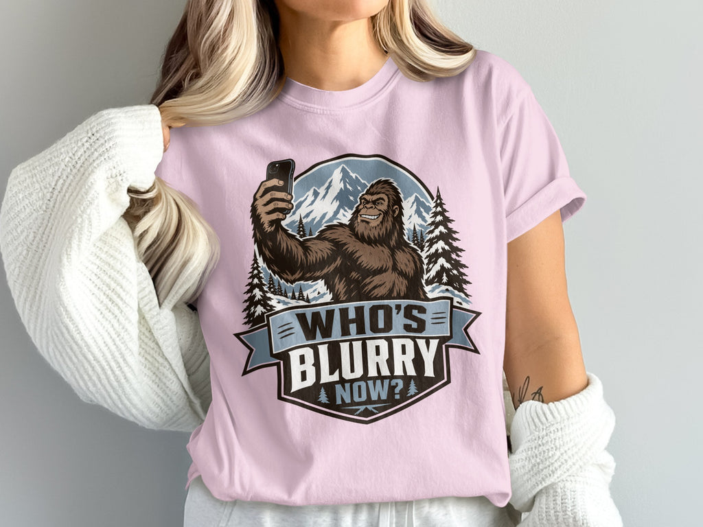 Bigfoot taking a selfie with mountains and text "Who's Blurry Now?".