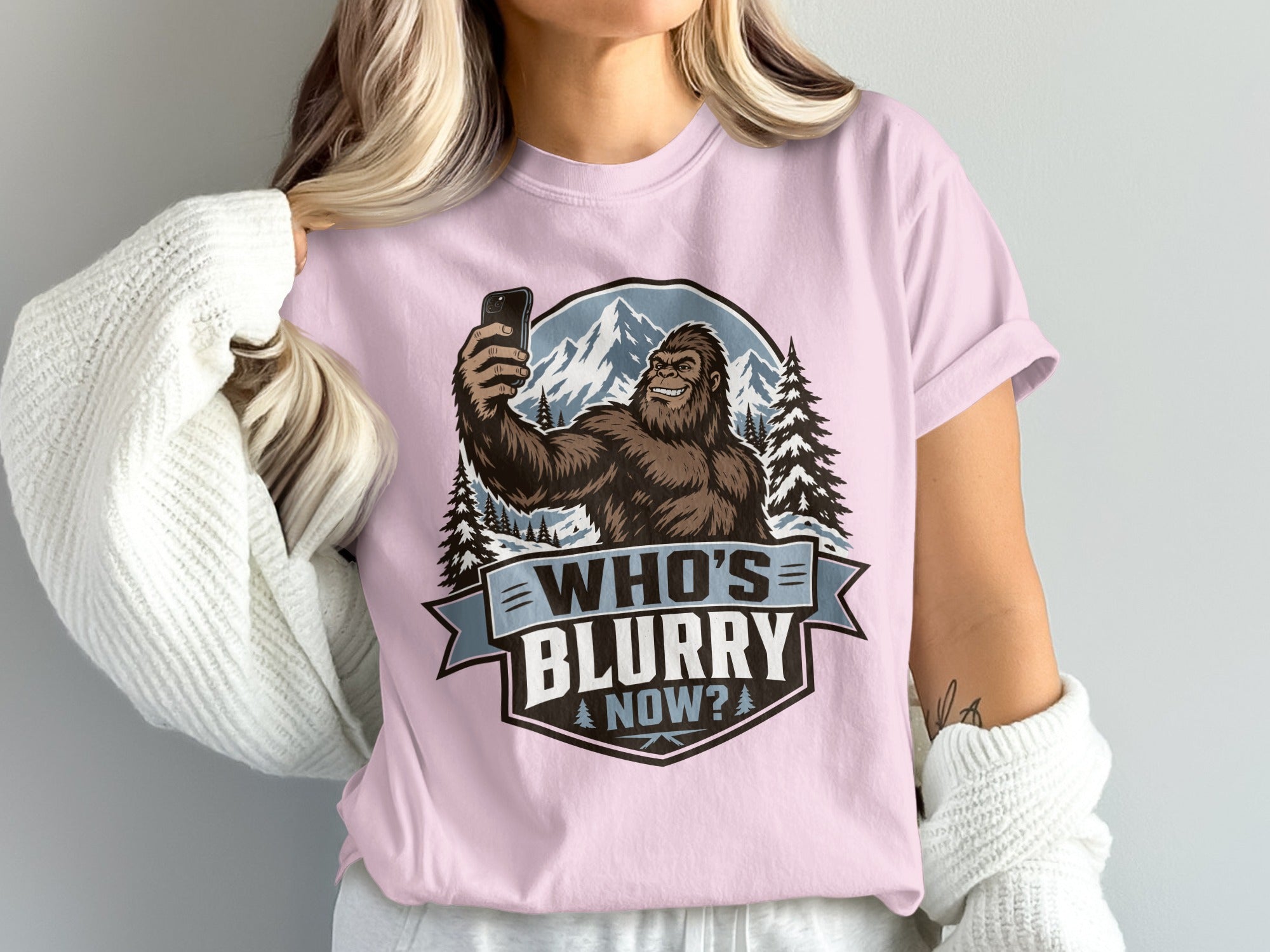 Bigfoot taking a selfie with mountains and text "Who's Blurry Now?".