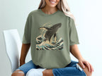 Green t-shirt with a breaching whale and stylized waves graphic.