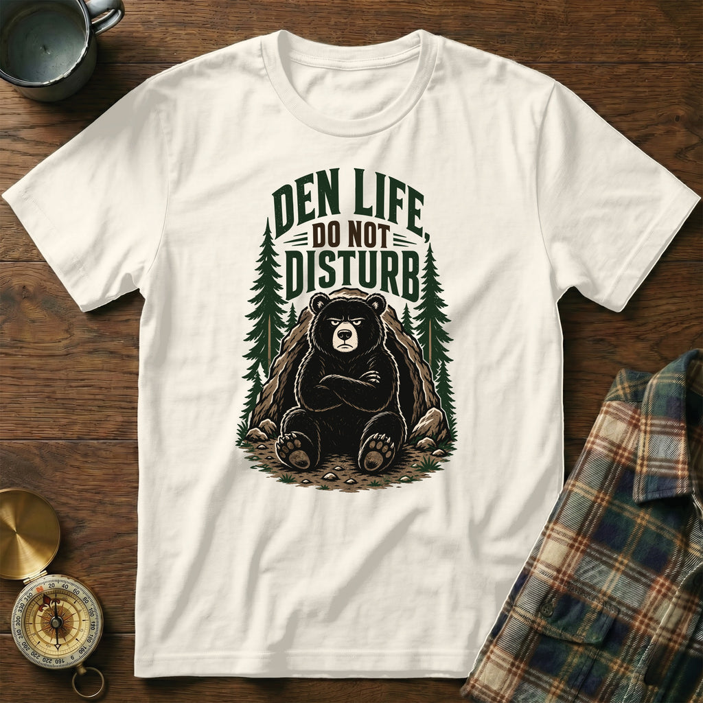 White t-shirt with a graphic of a bear in a den, reading "Den Life Do Not Disturb".