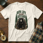 White t-shirt with a graphic of a bear in a den, reading "Den Life Do Not Disturb".
