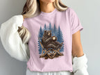 Bear sitting in chair with coffee mug in front of pine trees.