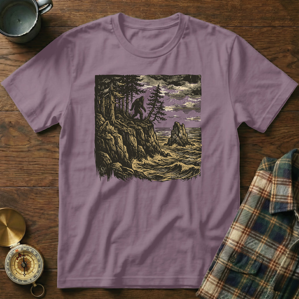 T-shirt with woodcut illustration of Bigfoot on a cliff overlooking a stormy sea.