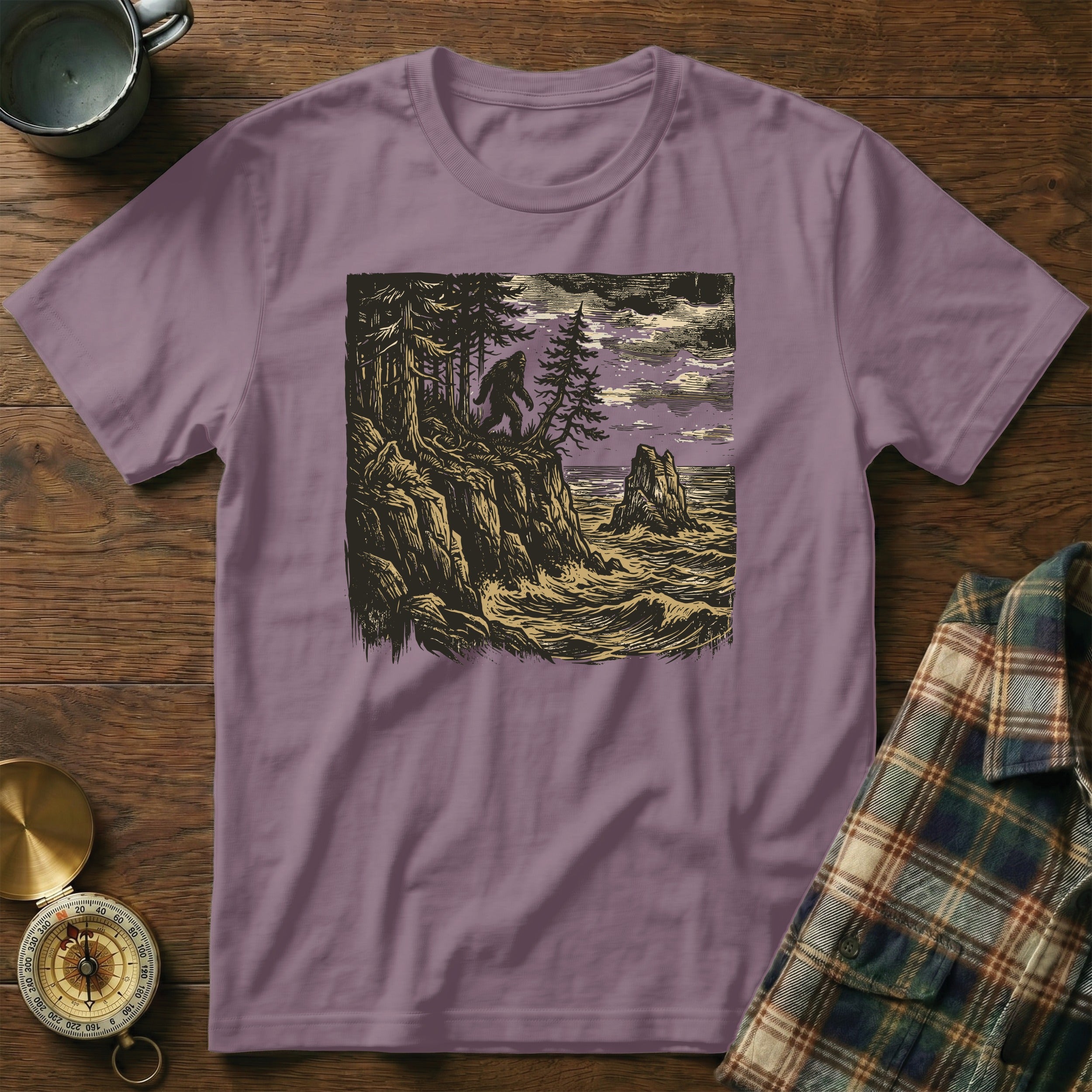 T-shirt with woodcut illustration of Bigfoot on a cliff overlooking a stormy sea.
